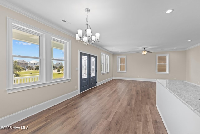 foyer entrance with hardwood / wood-style floors, ceiling fan with notable chandelier, french doors, and ornamental molding