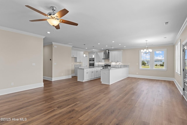 kitchen with dark hardwood / wood-style flooring, white cabinetry, hanging light fixtures, ornamental molding, and wall chimney exhaust hood