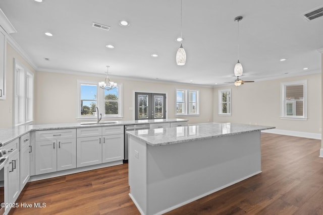 kitchen featuring dark wood-type flooring, sink, ceiling fan with notable chandelier, and white cabinetry