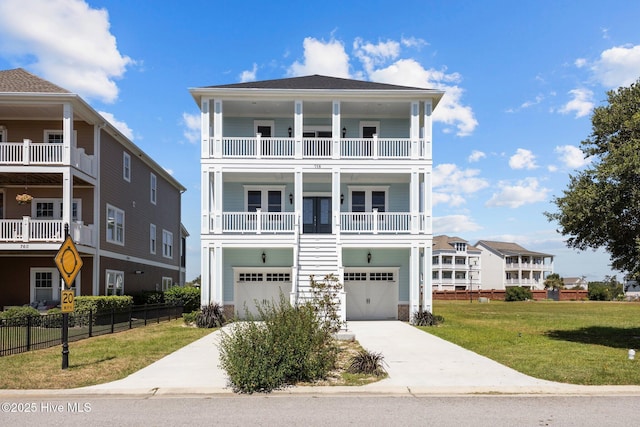 coastal home featuring a front yard, a balcony, and a garage