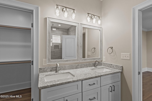 bathroom with a shower, ornamental molding, hardwood / wood-style flooring, and vanity