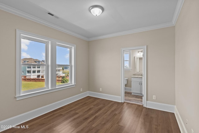 spare room with dark wood-type flooring and crown molding