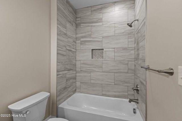 bathroom with toilet and tiled shower / bath