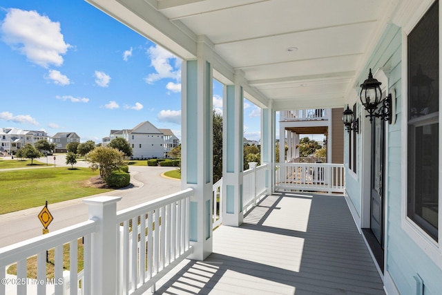 deck with a yard and covered porch