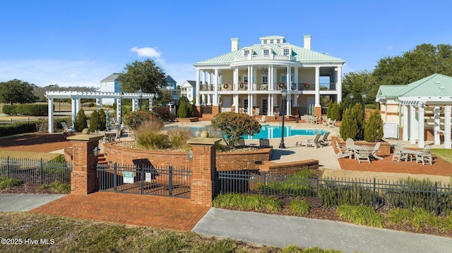 rear view of property with a patio area, a pergola, a community pool, and a balcony