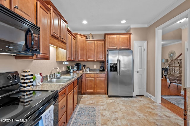 kitchen with sink, light stone counters, ornamental molding, and black appliances