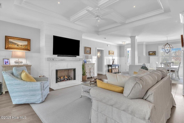 living room with ceiling fan, beamed ceiling, coffered ceiling, and ornamental molding