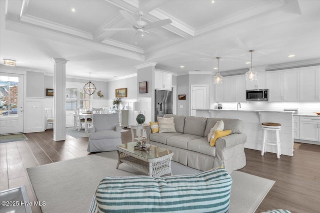 living room featuring coffered ceiling, dark hardwood / wood-style flooring, beamed ceiling, crown molding, and ceiling fan with notable chandelier