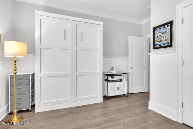 interior space with a closet, light hardwood / wood-style floors, and ornamental molding