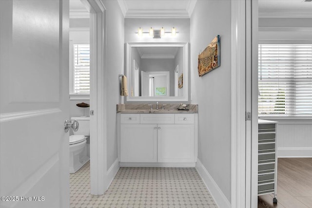 bathroom with crown molding, vanity, a healthy amount of sunlight, and toilet