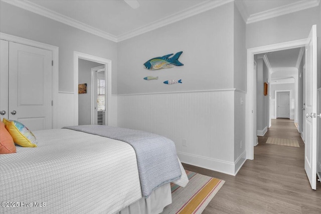 bedroom featuring wood-type flooring, a closet, and ornamental molding