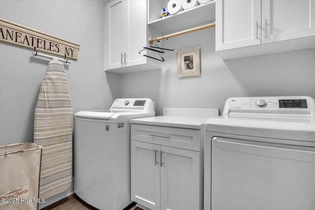 clothes washing area with washer and dryer and cabinets