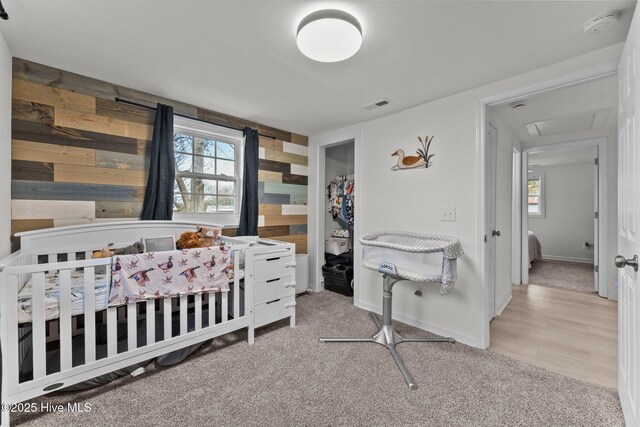 carpeted bedroom with a nursery area and multiple windows