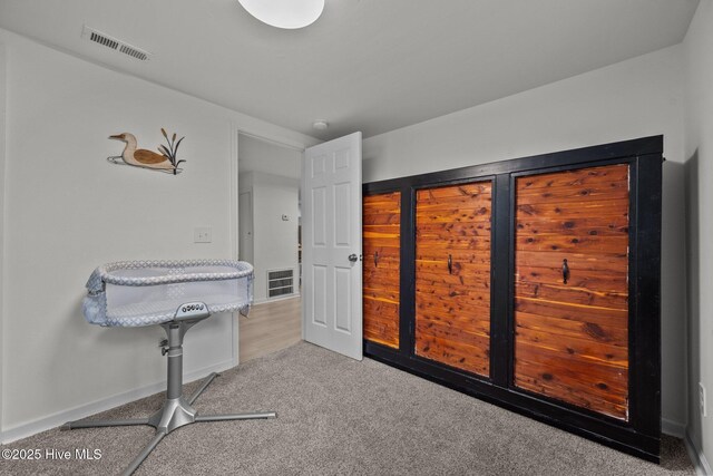 carpeted bedroom with wood walls