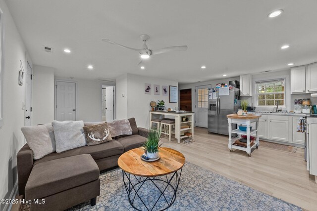 living room featuring light wood-type flooring and ceiling fan