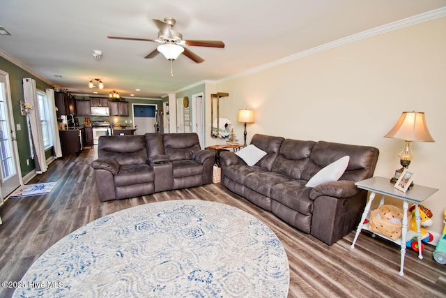 living room with ceiling fan, ornamental molding, and dark wood-type flooring