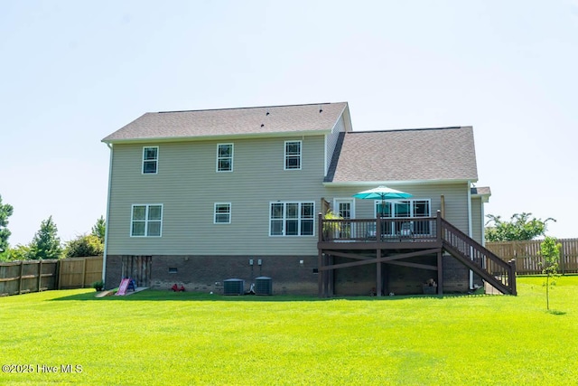 back of property with a yard, a wooden deck, and central AC