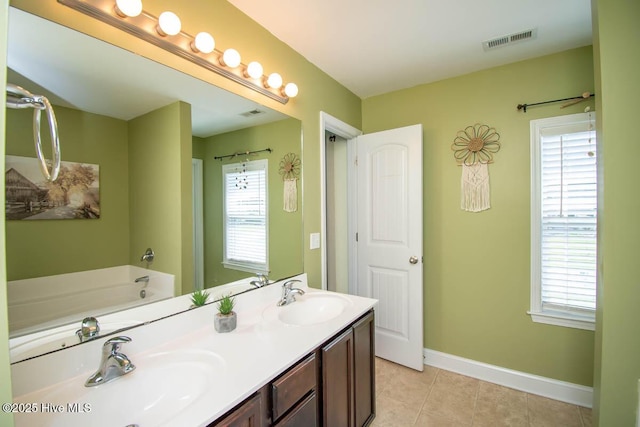 bathroom featuring a washtub, vanity, and tile patterned floors