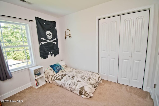 bedroom with light colored carpet and a closet