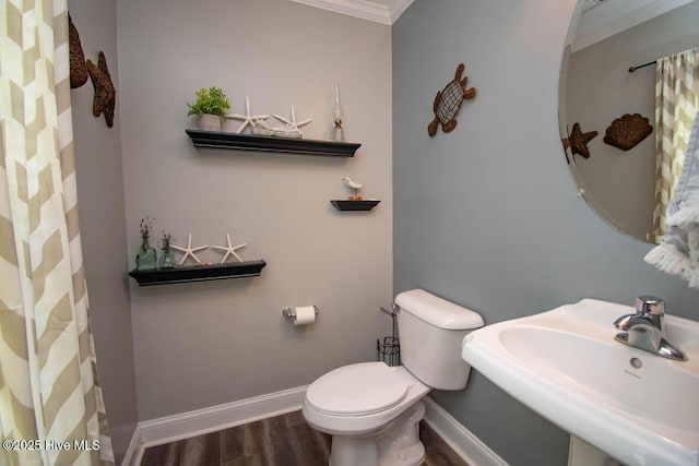 bathroom featuring hardwood / wood-style floors, toilet, crown molding, and sink