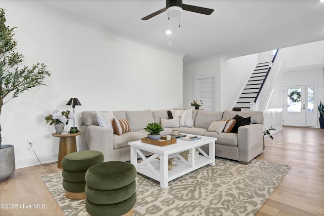 living room featuring crown molding, ceiling fan, and wood-type flooring