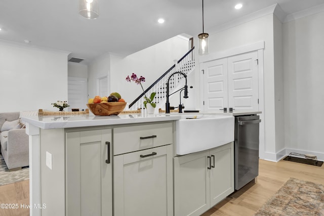 kitchen with crown molding, stainless steel dishwasher, a kitchen island, pendant lighting, and light hardwood / wood-style floors