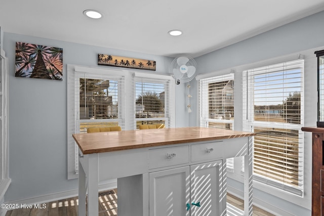 interior space with light wood-type flooring, butcher block counters, and white cabinets