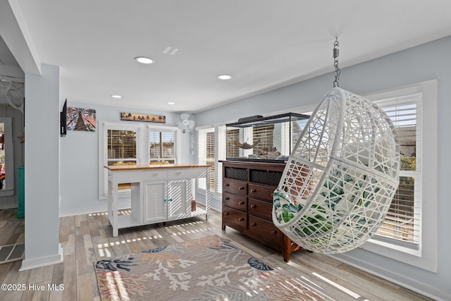 kitchen with a wealth of natural light, white cabinetry, and hardwood / wood-style flooring