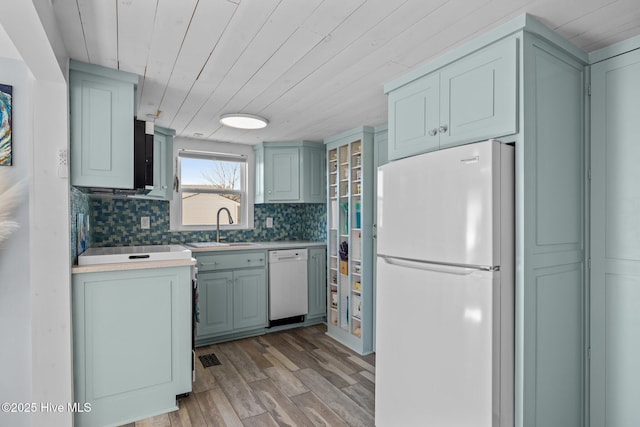 kitchen with decorative backsplash, sink, white appliances, light hardwood / wood-style flooring, and wood ceiling