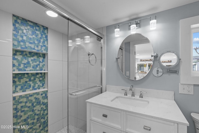 bathroom featuring toilet, an enclosed shower, and vanity