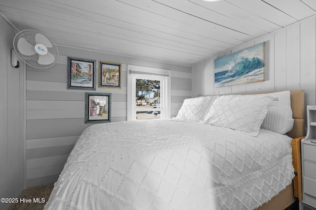 bedroom with wooden ceiling, carpet flooring, and wooden walls