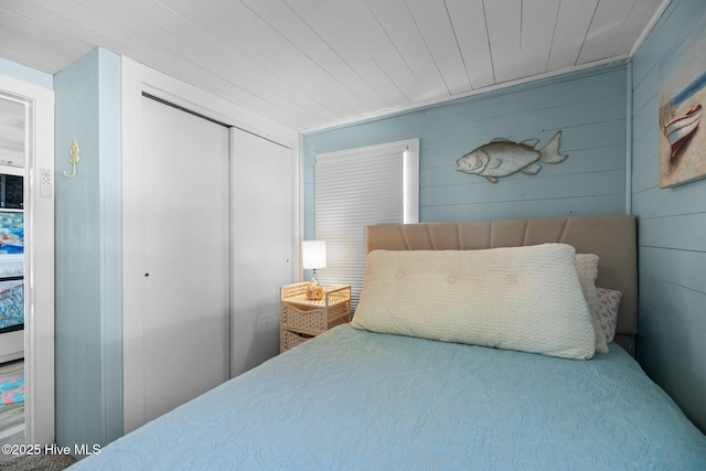 bedroom featuring a closet and wood walls