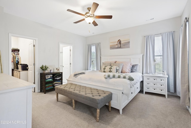 carpeted bedroom featuring a closet, a spacious closet, and ceiling fan