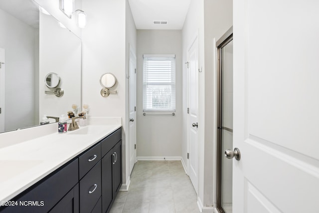 bathroom with vanity and a shower with door