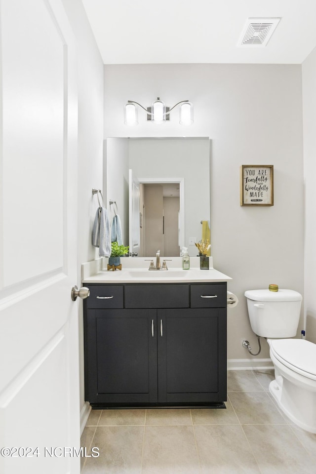 bathroom featuring tile patterned flooring, vanity, and toilet