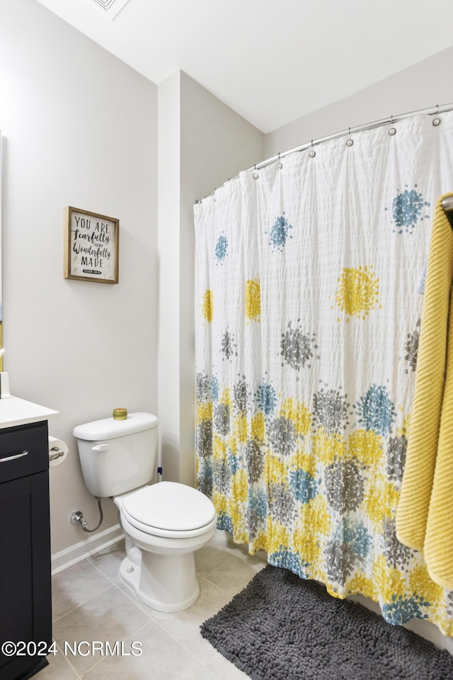 bathroom featuring tile patterned floors, vanity, toilet, and walk in shower