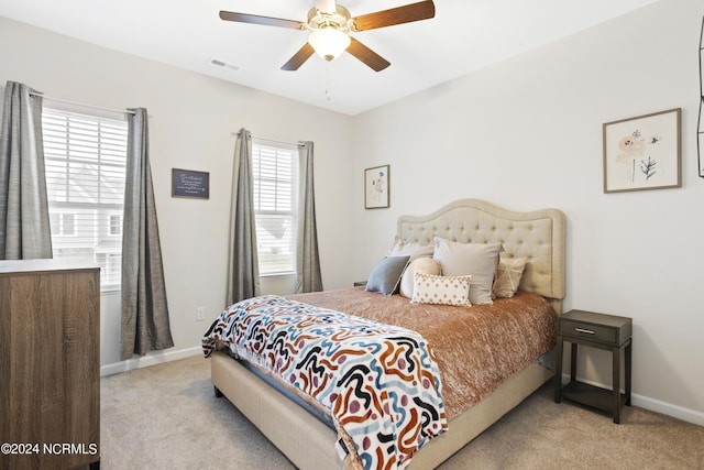 carpeted bedroom featuring multiple windows and ceiling fan