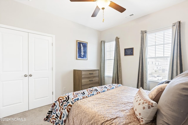 bedroom with ceiling fan, a closet, and light carpet