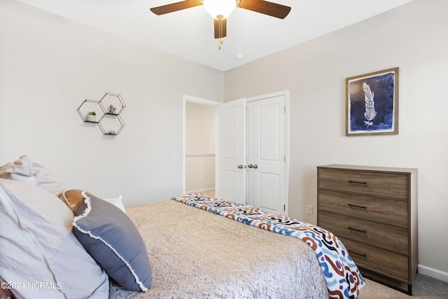 carpeted bedroom with ceiling fan and a closet