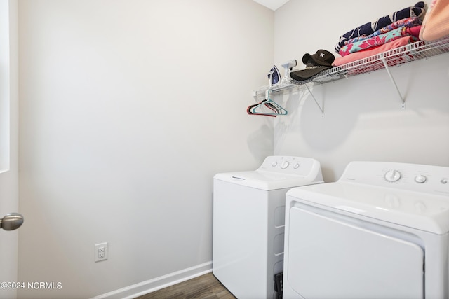 clothes washing area with separate washer and dryer and dark wood-type flooring