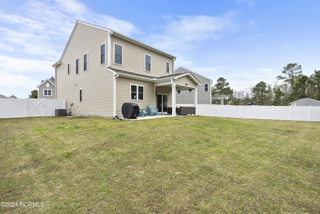 back of house featuring a lawn, cooling unit, and a patio area