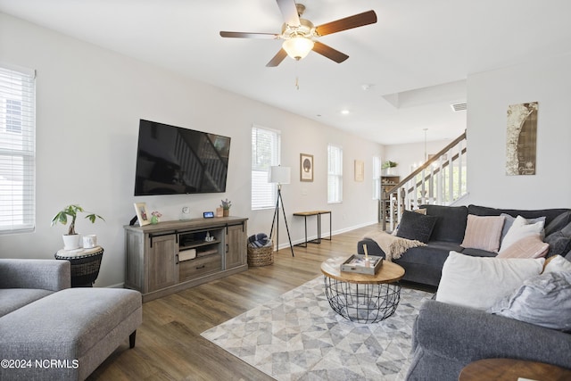 living room with wood-type flooring, ceiling fan with notable chandelier, and a healthy amount of sunlight