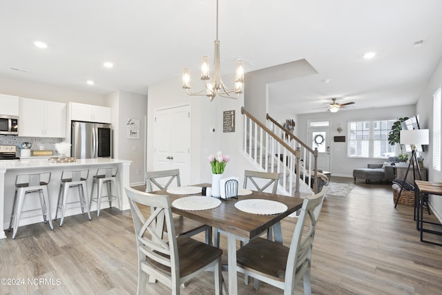 dining area with ceiling fan with notable chandelier and light wood-type flooring