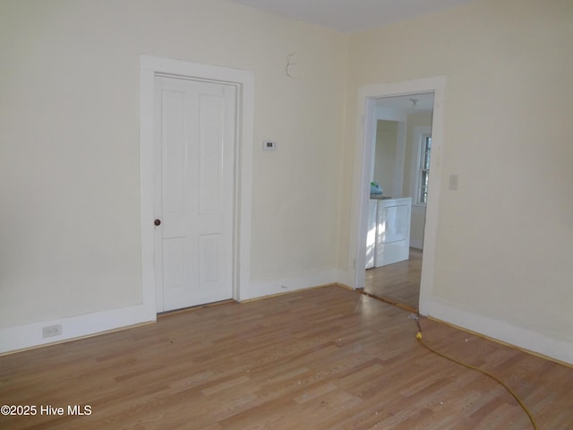 unfurnished room featuring washer and clothes dryer and light wood-type flooring