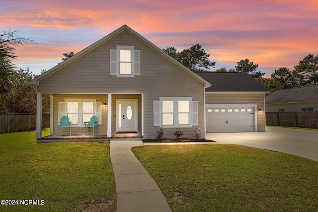 view of front of house featuring a porch, a yard, and a garage