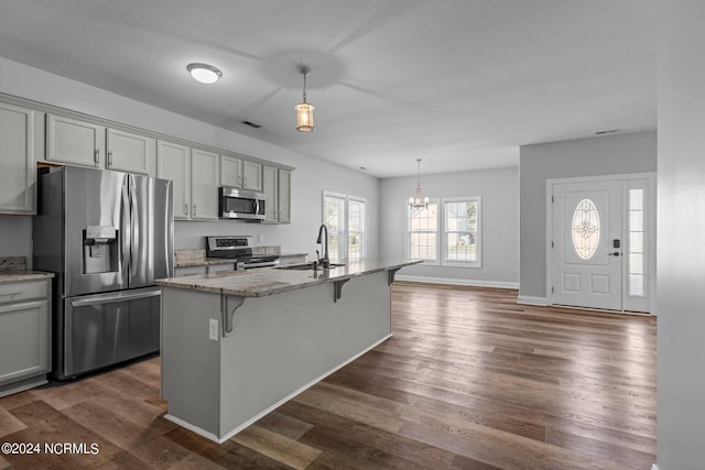 kitchen featuring gray cabinetry, a kitchen island with sink, and appliances with stainless steel finishes