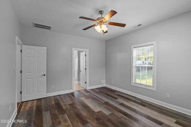 empty room featuring dark hardwood / wood-style flooring and ceiling fan