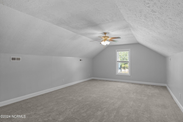 bonus room featuring a textured ceiling, ceiling fan, lofted ceiling, and carpet floors