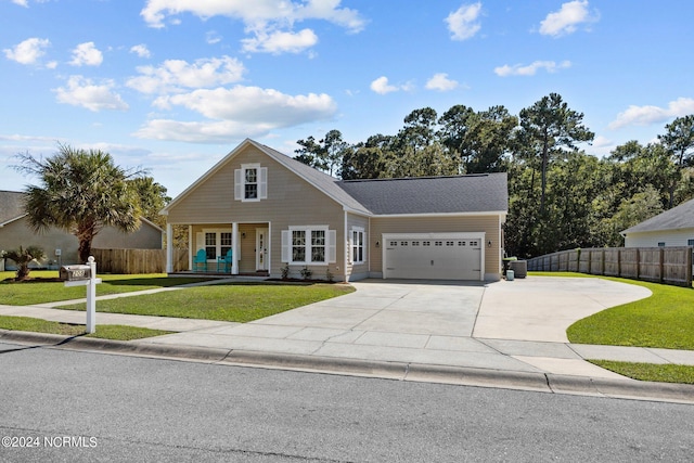 view of front of house featuring a front yard, a porch, and a garage