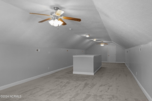 bonus room featuring lofted ceiling, ceiling fan, light carpet, and a textured ceiling